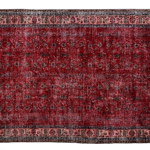 K&ouml;nnte beinhalten: Ein rechteckiger, verwaschen roter Teppich mit floralem Muster. Der Teppich hat ein verblasstes Aussehen, mit einem rosa Rand und einem dunkelgrauen und schwarzen Blumendesign. Der Teppich ist f&uuml;r ein Wohn- oder Schlafzimmer geeignet.