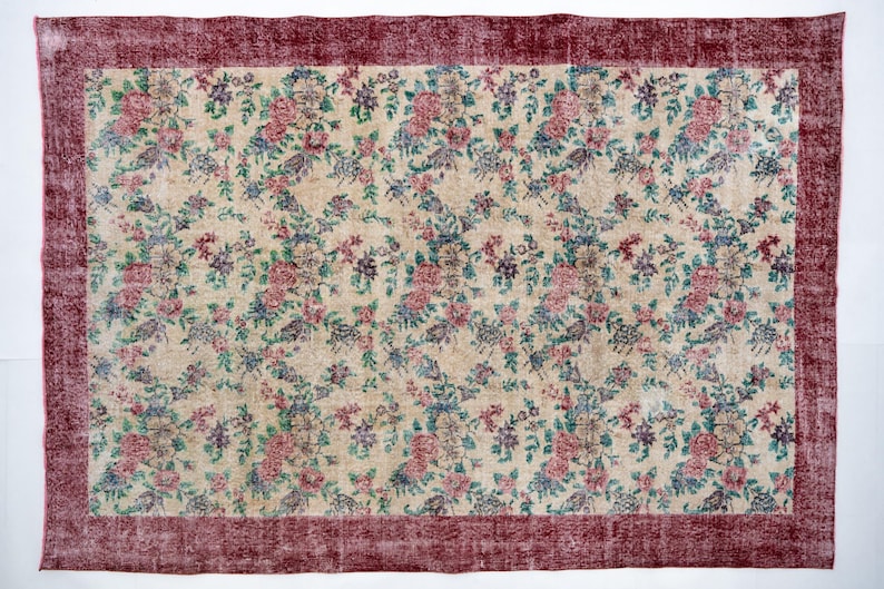 Pode incluir: Tapete retangular com um campo creme e um padr&atilde;o floral em tons de rosa, azul e verde. O tapete tem uma borda bord&ocirc; escura. Adequado para sala de estar ou quarto, cerca de 200 x 300 cm.