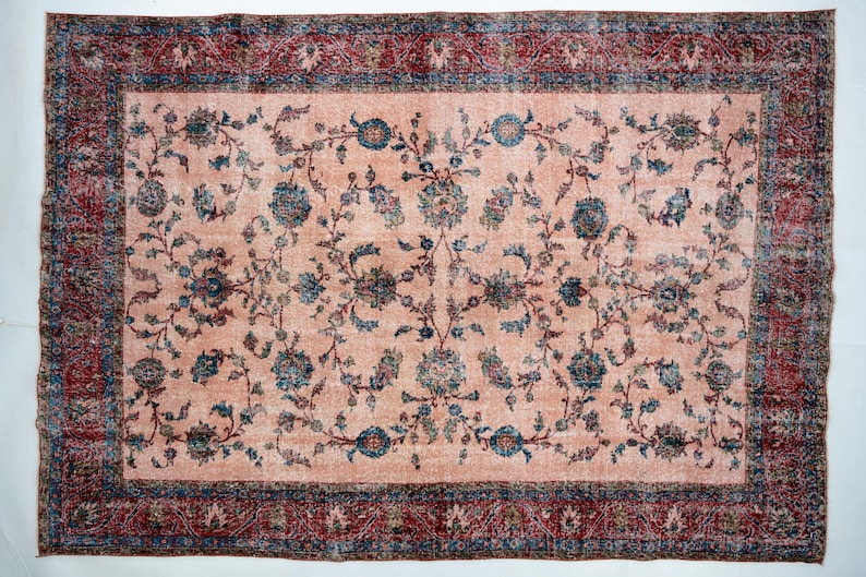 Pu&ograve; includere: Tappeto rettangolare con centro color pesca e motivo floreale in verde acqua e blu navy. Il bordo &egrave; rosso scuro con un design dettagliato. Il tappeto ha un aspetto vintage e usurato.