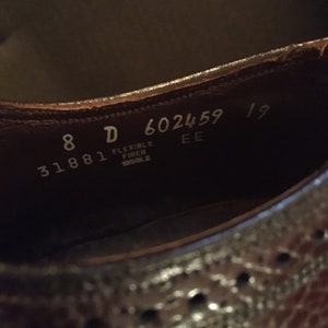 May include: Close-up of the inside of a brown leather shoe with the size 8 D and the text "31881 Flexible Fiber Sole" and "602459 EE 19".