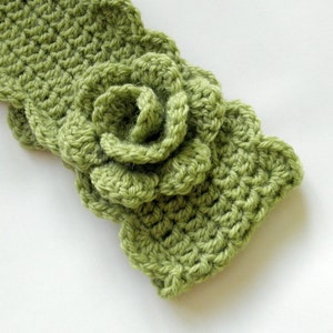 May include: A green crocheted headband with a large flower detail.