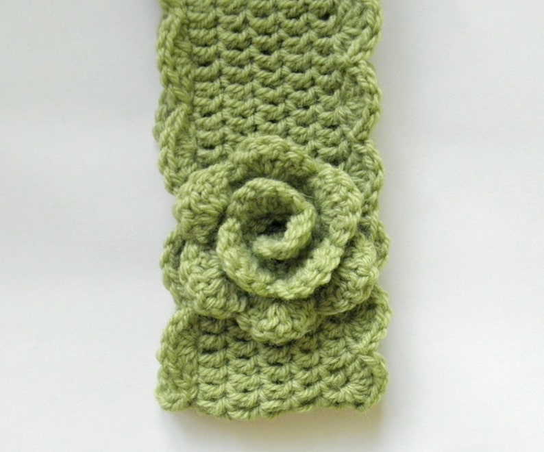 May include: A green crocheted headband with a large green crocheted flower.