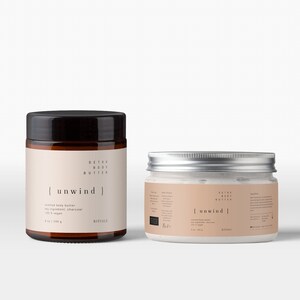 Op de afbeelding: Twee potten body butter tegen een witte achtergrond. De grotere pot heeft een donkerbruine deksel en een beige etiket met de tekst "unwind". De kleinere pot heeft een zilveren deksel en een vergelijkbaar etiket. Beide potten zijn gelabeld met "Detox Body Butter".