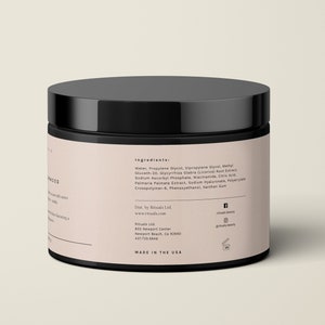 May include: A black jar with a black lid. The jar has a light pink label with white text listing ingredients and company information. The text "MADE IN THE USA" is printed on the bottom of the label.