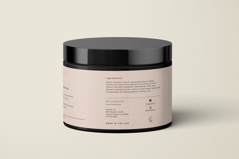 May include: A black jar with a black lid. The jar has a light pink label with white text listing ingredients and company information. The text "MADE IN THE USA" is printed on the bottom of the label.