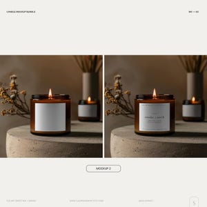 May include: Two amber glass candle jars with labels. The candle on the left has a blank label. The candle on the right has a label that reads "smoke + earth". Both candles are lit and have a warm glow. The candles are on a gray concrete surface with dried flowers in the background.