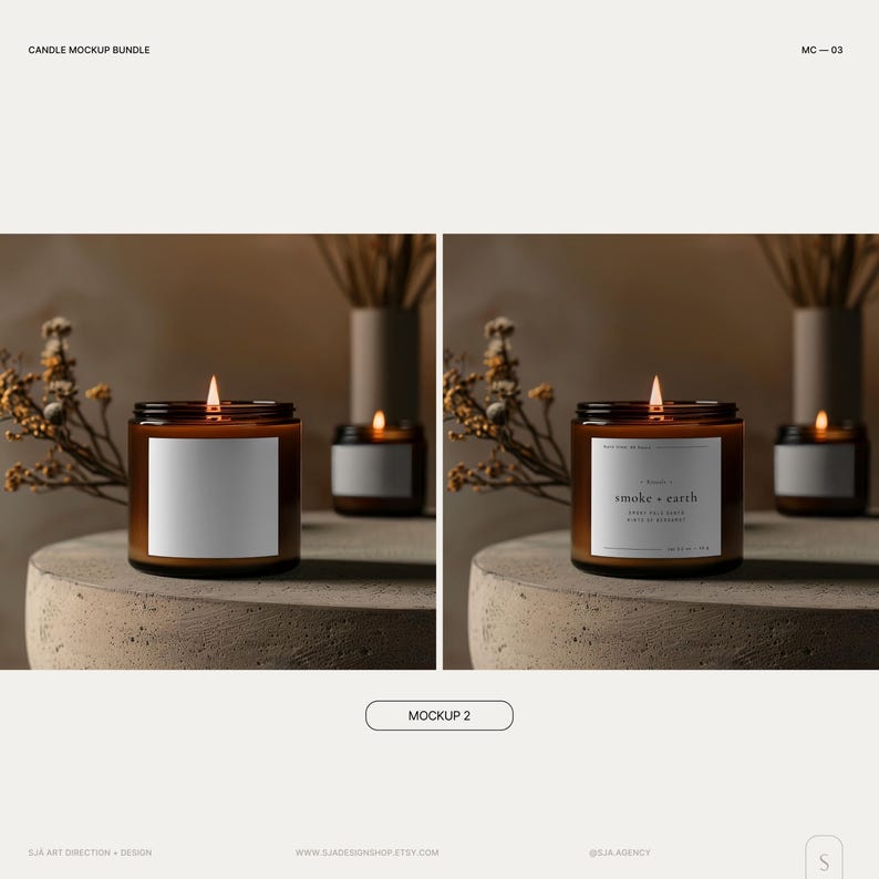 May include: Two amber glass candle jars with labels. The candle on the left has a blank label. The candle on the right has a label that reads "smoke + earth". Both candles are lit and have a warm glow. The candles are on a gray concrete surface with dried flowers in the background.