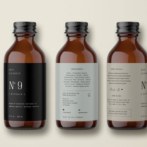May include: Three amber glass bottles with black lids and labels. The labels are white with black text and the words "Body Cleanser N&deg; 9 Rituals". The middle bottle has a label with the ingredients listed. The bottle on the right has a label with the text "About Rituals" and "How to Use".