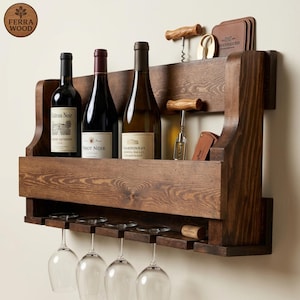 May include: A dark stained wooden wine rack with three wine bottles, four wine glasses, and corkscrews. The rack has a shelf for bottles and a lower rack for glasses. The wine bottles are labelled with wine varietals.