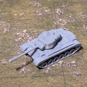 May include: A small, gray model tank with a long barrel and detailed tracks. The miniature military vehicle is set against a textured, green and brown background, suggesting a battlefield or terrain.