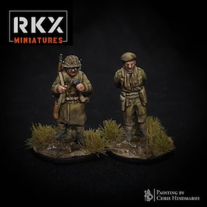Könnte beinhalten: Zwei Miniatur-Militärfiguren in olivgrünen Uniformen, eine mit Gewehr und Fernglas, die andere mit den Händen auf dem Rücken. Sie stehen auf einer Basis mit Gras. Das Bild enthält den Text "RKX MINIATURES" und "PAINTING BY CHRIS HINDMARSH".