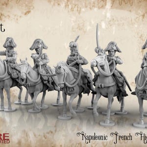 May include: A group of grey miniature figurines of Napoleonic French Hussars on horseback. The figures are detailed with historical uniforms and weaponry, including swords and hats. The figures are arranged in a line, suggesting a battle formation.