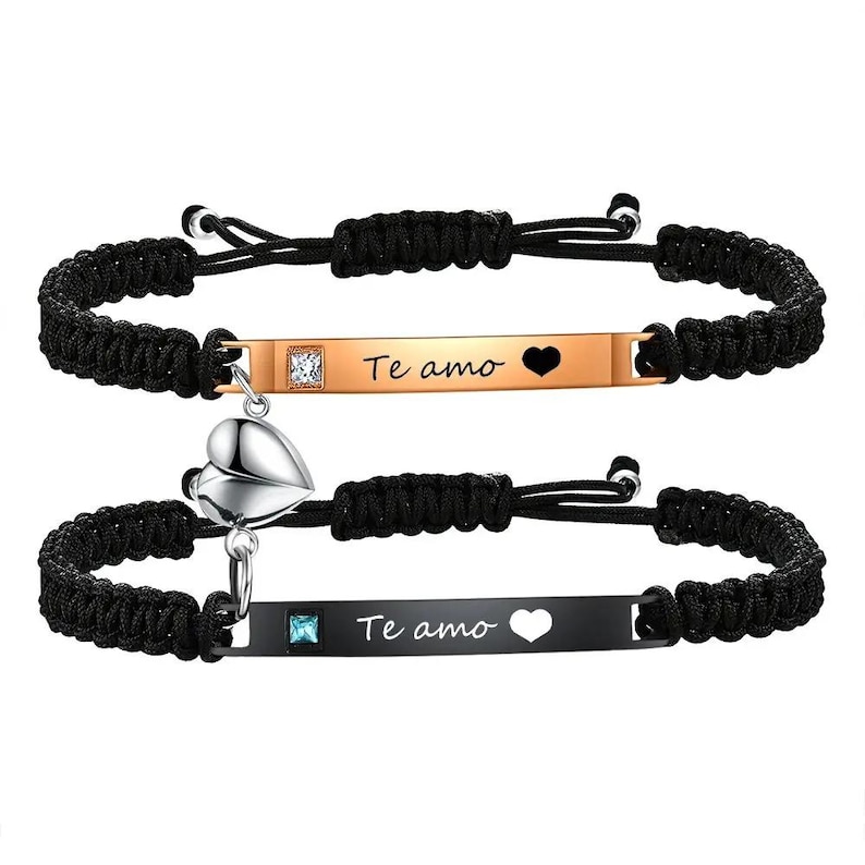 May include: Two matching black braided bracelets. One bracelet has a gold-colored bar with the text "Te amo" and a heart cutout. The other bracelet has a black bar with the same text and a heart cutout. Both bracelets have a heart-shaped charm.