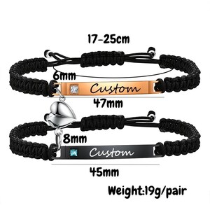May include: Two matching black braided bracelets with adjustable cords. One bracelet has a gold-colored bar with "Custom" text and a square gem. The other has a black bar with "Custom" text and a heart charm. The bracelets are 17-25cm long.