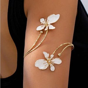 Armband med öppen manschett och blommig emalj, guldfärgat armband