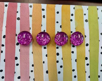 Può includere: Quattro cabochon rotondi magenta glitterati sono allineati. Sono posti su uno sfondo colorato a strisce verticali rosa, bianche, gialle e verdi, con pois neri. Adatti per lavori creativi.