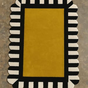 May include: A rectangular rug featuring a solid mustard yellow center panel surrounded by a thick black border. The outer edge of the rug is finished with a scalloped trim that alternates between black and off-white vertical stripes.