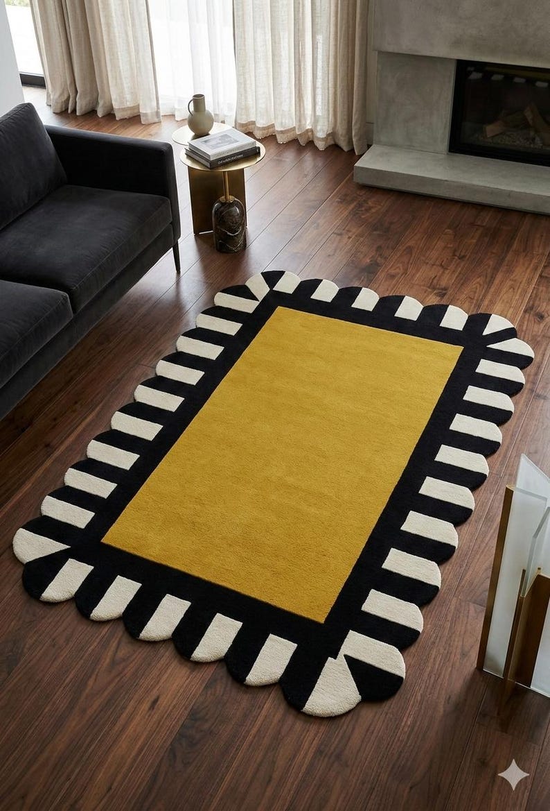 May include: A rectangular area rug featuring a solid mustard yellow center panel surrounded by a wide black border. The border is decorated with a repeating pattern of cream-colored semi-circular scallops along the entire outer edge.