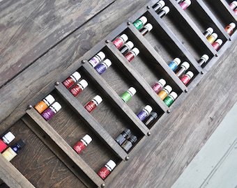 May include: A wooden wall shelf with multiple rows of small glass bottles filled with colorful liquids. The bottles are arranged in a staggered pattern, creating a visually appealing display.
