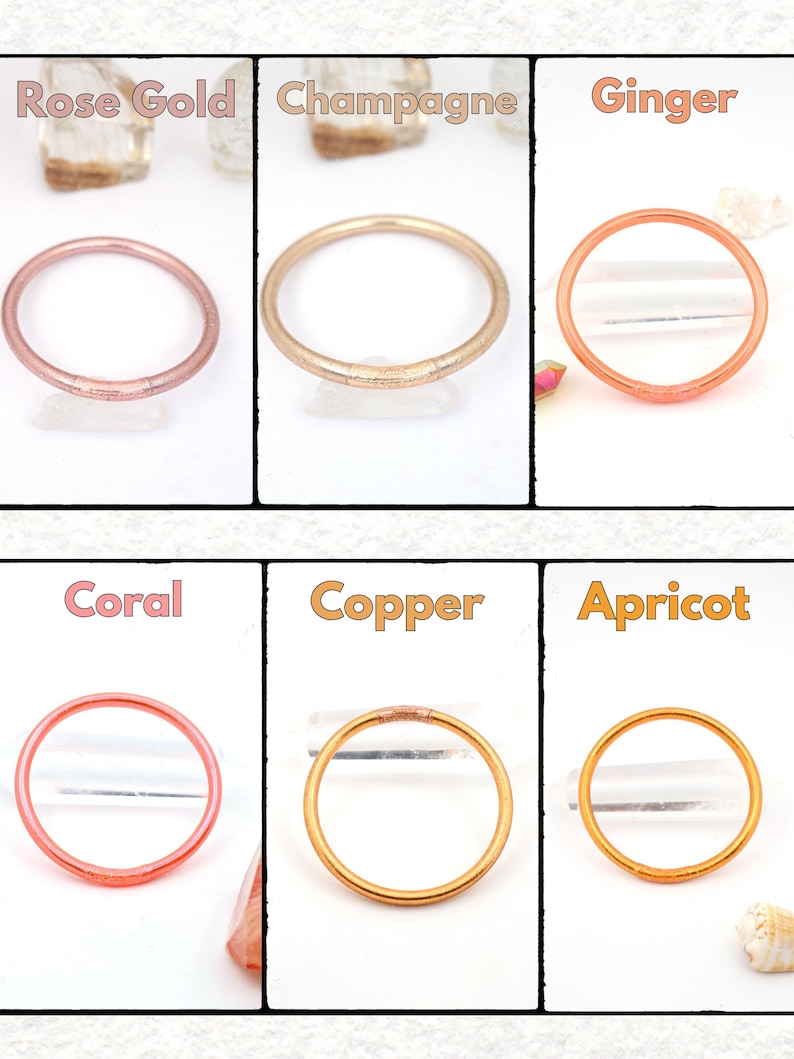May include: Six colorful bangles in rose gold, champagne, ginger, coral, copper, and apricot. Each bangle is a simple, round design. The names of the colors are written above each bangle.