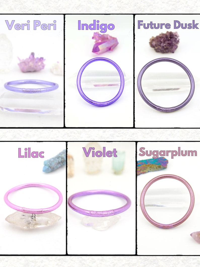 May include: Six colorful bangles in shades of purple, pink, and lavender are displayed. The colors are labeled: Veri Peri, Indigo, Future Dusk, Lilac, Violet, and Sugarplum. Each bangle is a solid color and appears to be made of a flexible material.