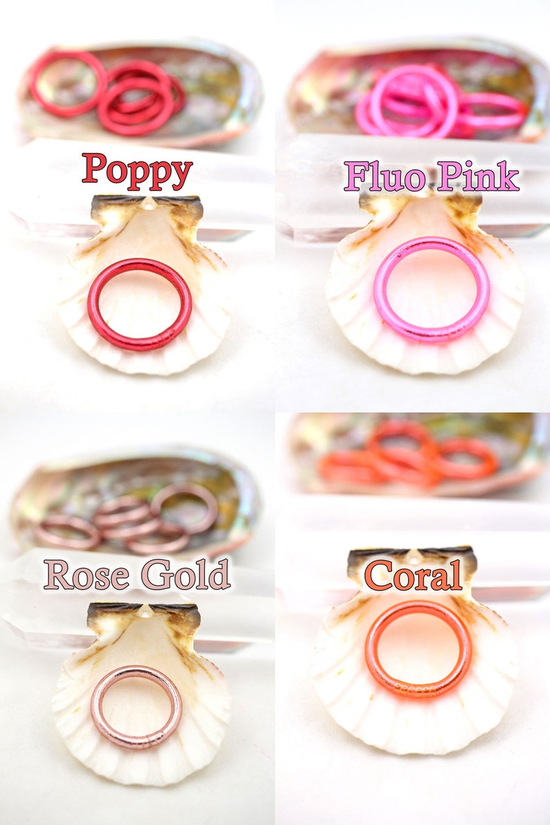 May include: Four seashells each containing a different color of metal rings. The colors are poppy, fluo pink, rose gold, and coral.