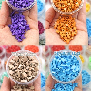 K&ouml;nnte beinhalten: Vier Beh&auml;lter mit bunten, kleinen, plastikartigen Pfeil-f&ouml;rmigen Perlen. Die Farben sind Amethyst, Amberglow, warmes Taupe und Himmelblau.