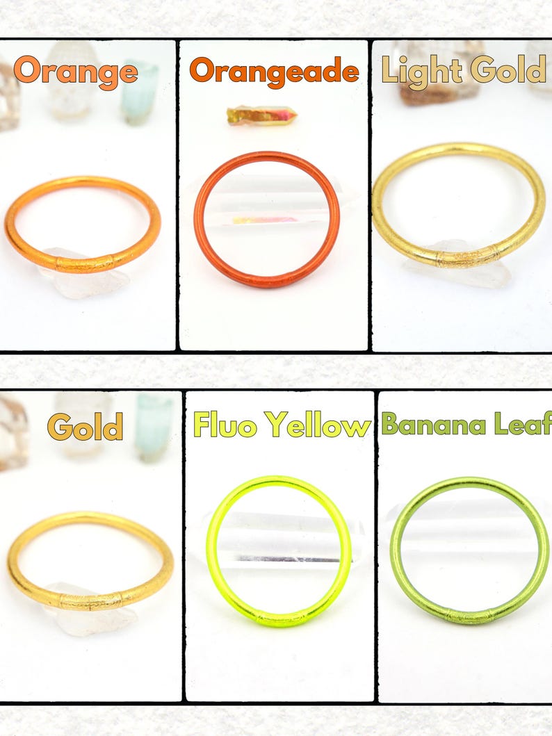 May include: A collection of colorful, thin, circular rings in various shades, including orange, light gold, gold, and fluo yellow. Each ring is displayed against a white background, with the color name labeled above each ring.