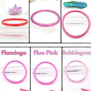 May include: A collection of six colorful bangles in shades of red, pink, and purple. Each bangle is a simple, thin circle. The colors are labeled "Poppy", "Ruby", "Cordovan", "Flamingo", "Fluo Pink", and "Bubblegum".