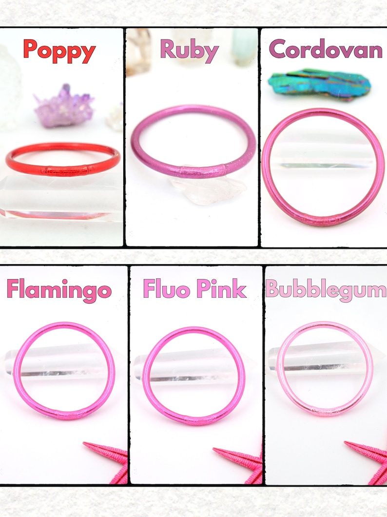 May include: A collection of six colorful bangles in shades of red, pink, and purple. Each bangle is a simple, thin circle. The colors are labeled "Poppy", "Ruby", "Cordovan", "Flamingo", "Fluo Pink", and "Bubblegum".