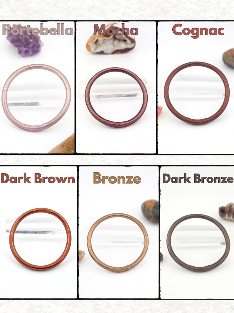 May include: Six circular hair ties in various colors: Portobella, Mocha, Cognac, Dark Brown, Bronze, and Dark Bronze. Each tie is displayed against a white background with a small decorative stone.