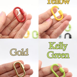 Puede incluir: Cuatro cierres de langosta de metal de diferentes colores: rojo, amarillo, dorado y verde. Cada cierre se sostiene en una mano.