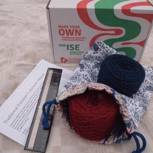 Pu&ograve; includere: Un kit per realizzare guanti tradizionali estoni in colorwork. Il kit include due gomitoli di lana, uno rosso e uno blu, un set di ferri da maglia e una borsa con coulisse con un motivo floreale. La scatola presenta il testo "Make Your Own Traditional Estonian Colorwork Mittens" e "KOO'ISE ehedad Eesti kirikindad".