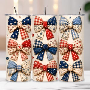 May include: A cylindrical tumbler with a metal straw featuring a repeating pattern of decorative bows in various red, white, and blue fabric designs. The bows display diverse textures including stars, gingham checks, polka dots, and floral prints on a cream background.