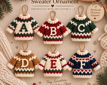 May include: Six crocheted sweater ornaments with hanging loops, each featuring a unique letter from A to F. The sweaters display various color combinations including cream, red, green, brown, and navy blue with geometric patterns and text.