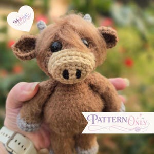 May include: A brown crocheted Highland cow plush toy with a fuzzy texture, dark eyes, and a light tan muzzle featuring two black nostrils. The toy has small grey horns and grey hooves. The image includes the text MohyKi and Pattern Only.