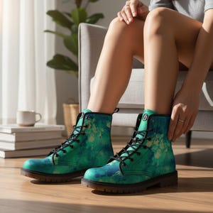 Może przedstawiać: Teal i niebieskie buty bojowe z akwarelowym wzorem. Buty mają czarne sznurowadła, czarną podeszwę i małą czarną zakładkę na górze. Buty są noszone przez osobę siedzącą na szarym krześle.