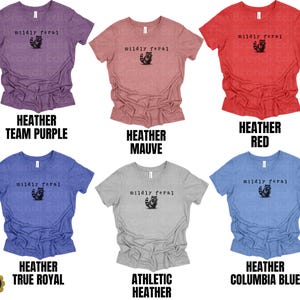 Puede incluir: Seis camisetas de manga corta y cuello redondo en colores heather team purple, heather mauve, heather red, heather true royal, athletic heather y heather columbia blue. Cada una tiene el texto negro "mildly feral" sobre un peque&ntilde;o gr&aacute;fico de un mapache.