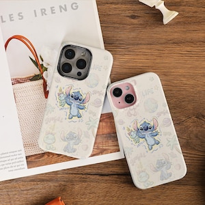 Puede incluir: Dos fundas blancas para teléfono con un personaje de dibujos animados, Stitch, en tonos azules y rosas. Las fundas tienen un patrón repetido de Stitch, planetas y palmeras. La palabra "LIFE" está impresa en una de las fundas.