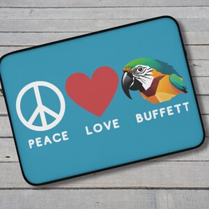 Può includere: Una custodia per laptop turchese con un simbolo di pace bianco, un cuore rosso e un'illustrazione di pappagallo colorato. Le parole "PEACE LOVE BUFFETT" sono stampate in bianco. La custodia ha un bordo nero.