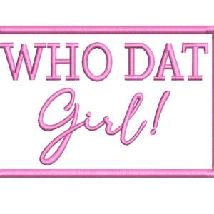 Pode incluir: Design bordado rosa sobre fundo branco. O texto "WHO DAT Girl!" está dentro de uma moldura retangular rosa. A letra é cursiva.
