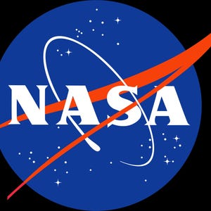 May include: The NASA logo, a blue circular emblem with the word "NASA" in white capital letters. An orange swoosh arcs across the logo, with a white orbital path and white stars in the background. The logo is set against a black background.