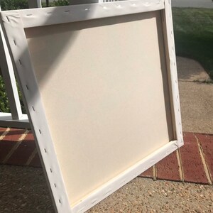 May include: A white canvas stretched over a wooden frame. The canvas is blank and ready for painting.