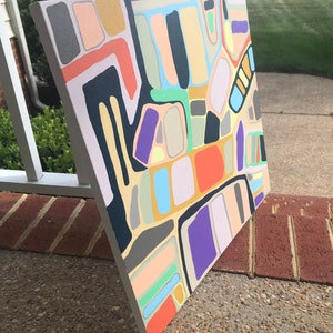 May include: Abstract painting on canvas with geometric shapes in various colors, including black, white, red, orange, yellow, green, blue, purple, and brown.