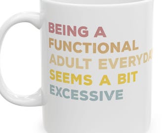 Könnte beinhalten: Weiße Keramiktasse mit dem Text "BEING A FUNCTIONAL ADULT EVERYDAY SEEMS A BIT EXCESSIVE" in einer farbenfrohen, geschichteten Schriftart. Die Tasse hat einen gebogenen Henkel und ein glänzendes Finish.