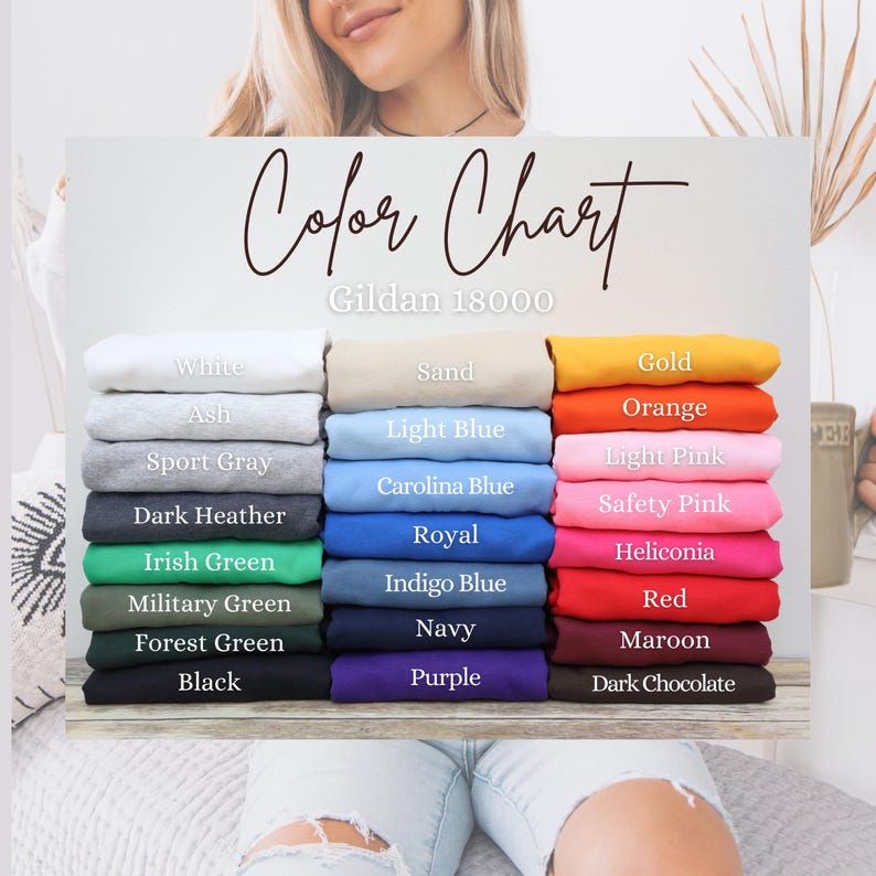 May include: A color chart for Gildan 18000 apparel, featuring a variety of colors. The chart displays folded fabric samples in shades like white, ash, sport gray, dark heather, and black. Other colors include light blue, orange, and red.