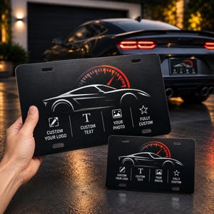 May include: Two rectangular black license plates featuring a white outline of a sports car and a red speedometer graphic. The plates display icons and text: CUSTOM YOUR LOGO, CUSTOM TEXT, YOUR PHOTO, and FULLY CUSTOM, with mounting slots at the top.