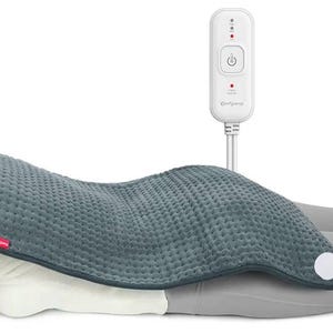 May include: A gray heating pad with a textured surface and a white control panel. The pad is curved and covers the lower back area. The control panel has a power button and heat settings.