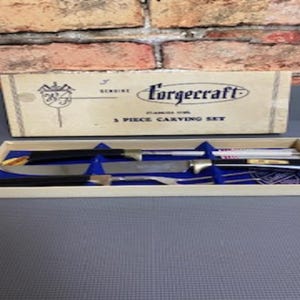 May include: A vintage Forgcraft 3-piece carving set in its original box. The set includes a carving knife, a carving fork, and a sharpening steel. The handles are black, and the blades are stainless steel. The box is beige with black text.