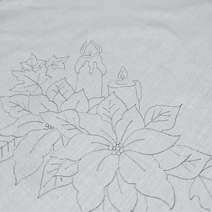 May include: A black and white line drawing of a poinsettia flower with two candles. The candles are tall and thin with flames at the top. The poinsettia flower has five petals and is surrounded by leaves.